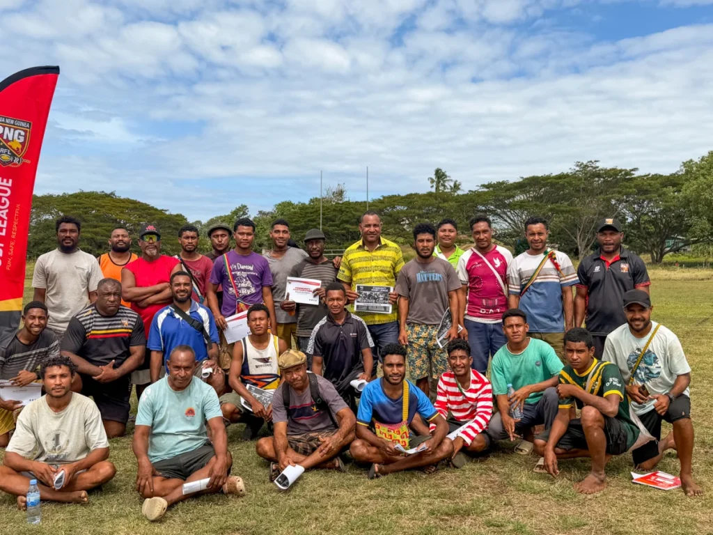 Community rugby league participants with a PNGRFL banner
